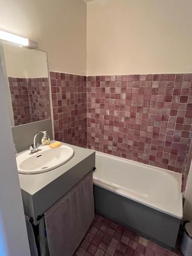 une salle de bain avec un lavabo et une baignoire dans l'établissement Studio lumineux, avec vue mer - Conciergerie Regnier -, à Sausset-les-Pins