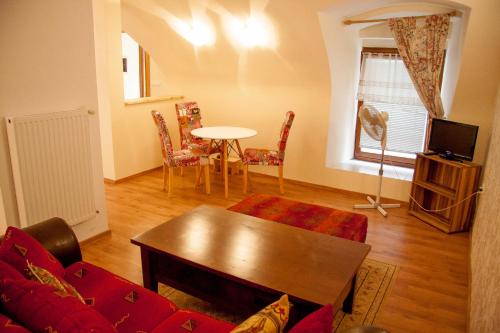 salon z czerwoną kanapą i stołem w obiekcie Baščaršija Apartments & Rooms w Mariborze