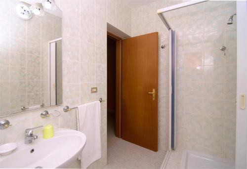 La salle de bains est pourvue d'un lavabo et d'une douche avec un miroir. dans l'établissement Le Acacie, à Castellammare di Velia