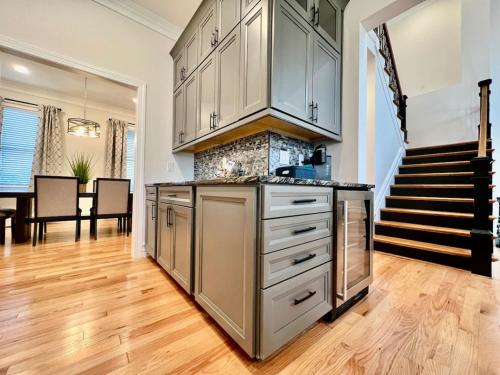 a kitchen with white cabinets and a wooden floor at NEW, big, beautiful, Executive Home Liberty Twp in Middletown