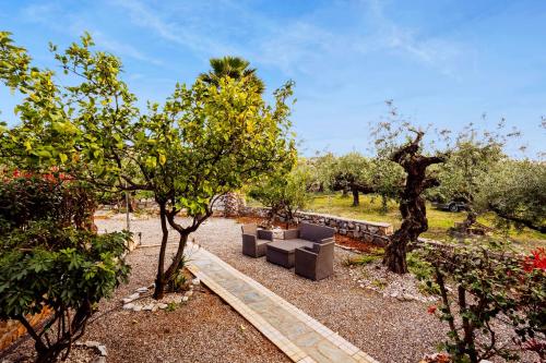 un jardín con un sofá en medio de árboles en Stoupa Serene Nests - Spitiko Getaway, en Stoupa