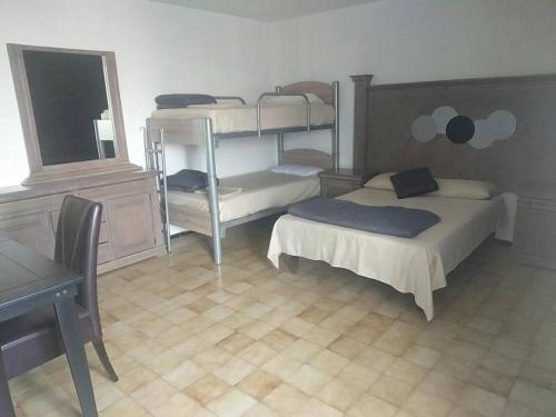 1 Schlafzimmer mit 2 Etagenbetten und einem Schreibtisch in der Unterkunft Casa Sol, Residencia para Grupos 22 personas, Cerca a la FERIA in Aguascalientes