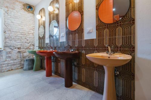 a bathroom with three sinks and two mirrors at 2nd Station Hostel in Bled