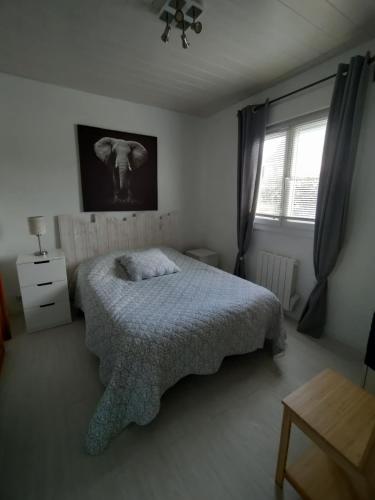 ein Schlafzimmer mit einem Bett und einem Bild eines Elefanten in der Unterkunft Chambre d hôte des Abers in Lannilis