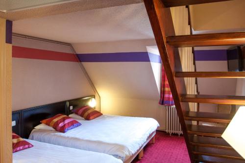 a bedroom with two bunk beds and a staircase at Hôtel Saint Sauveur in Lourdes