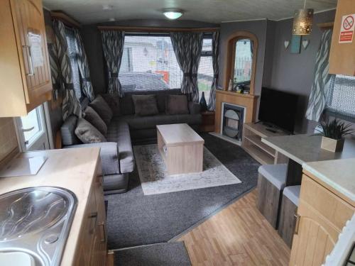 an rv living room with a couch and a tv at Sunnyside - Pet friendly, Ingoldmells in Ingoldmells