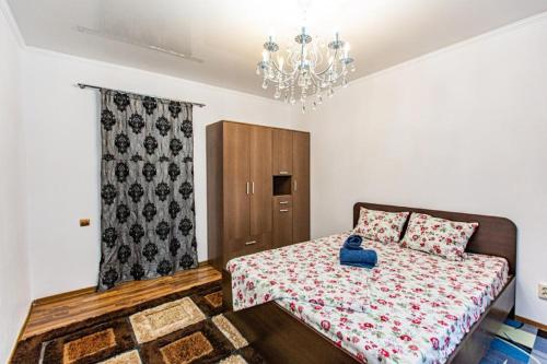 a bedroom with a bed and a chandelier at Maulenova 32.36 kv41 in Almaty