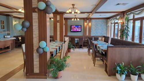 een eetkamer met tafels en stoelen en een tv bij Relax Holiday Complex & Spa in Sunny Beach