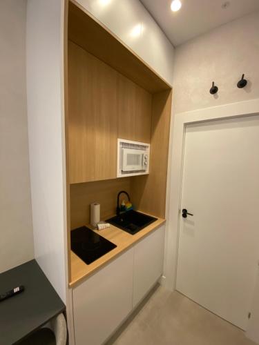 a small kitchen with a sink and a microwave at Apartamentos "El collado Suites" Soria Centro in Soria