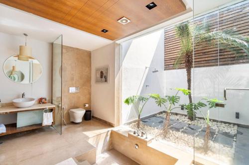 a bathroom with a tub with plants in it at Sea View Luxury Villa with 2 Swimming Pools in Dabolim