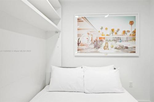 - une chambre dotée d'un lit blanc avec une photo sur le mur dans l'établissement Ocean View Cozy Studio Pool and Gym, à Miami