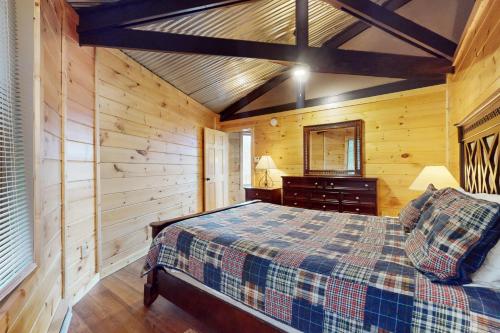 a bedroom with a bed and a wooden wall at Slopesider 26 in Sugar Mountain