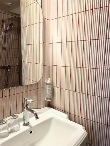 a bathroom with a sink and a mirror at Hôtel La Tour Intendance in Bordeaux