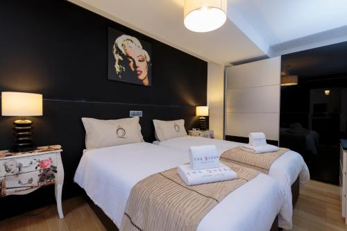 two beds in a hotel room with white sheets at The Queen Luxury Apartments - Villa Marilyn in Luxembourg