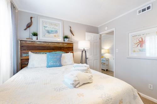 een slaapkamer met een groot wit bed met blauwe kussens bij Dunes Villas D4 in Hilton Head Island