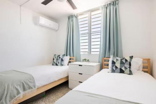 1 dormitorio con 2 camas y ventana en Encanto house with king bed, en Isabela