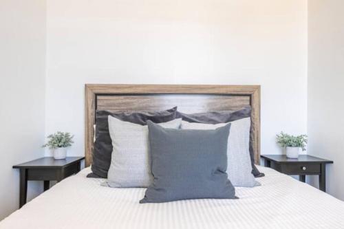 a bed with a wooden headboard and pillows at Encanto house with king bed in Isabela
