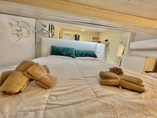 ein großes weißes Bett mit zwei Handtüchern darauf in der Unterkunft Un Piccolo Rifugio nel Borgo in Bergamo