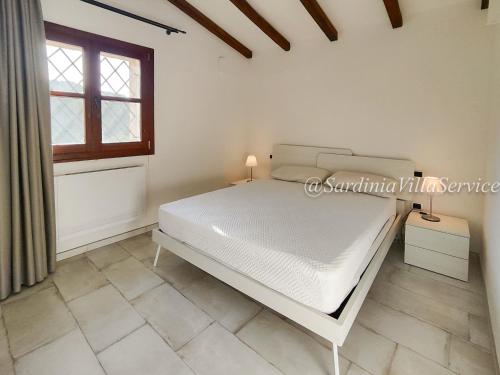 um quarto branco com uma cama e uma janela em Villa Lilium em Cannigione