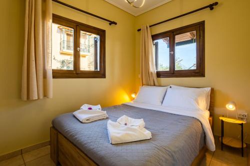 a bedroom with a bed with two towels on it at Stoupa Serene Nests - Spitiko Getaway in Stoupa