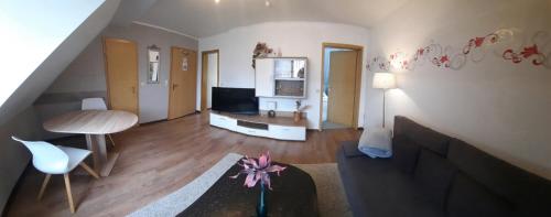 uma sala de estar com um sofá e uma mesa em Ferienwohnungen Ansbach - Ansbach Apartments - Your home away from home! em Ansbach