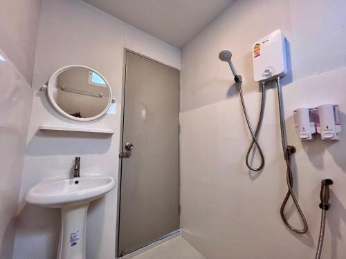 La salle de bains est pourvue d'un lavabo, d'un miroir et d'une douche. dans l'établissement MrT Riverside Sampran มิสเตอร์ที โฮมสเตย์-ทองกวาว, à Sam Phran