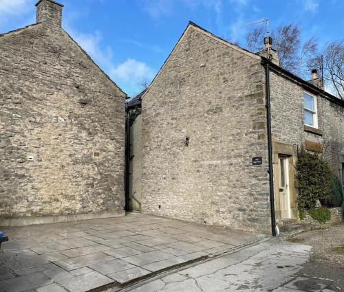 a large brick building with a large door at Peaceful cottage Peak District, nr Bakewell in Buxton