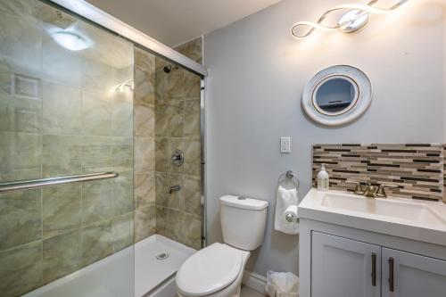 a bathroom with a shower and a toilet and a sink at Serenity by the Falls - Modern 2 Bedroom Hideaway in Niagara Falls