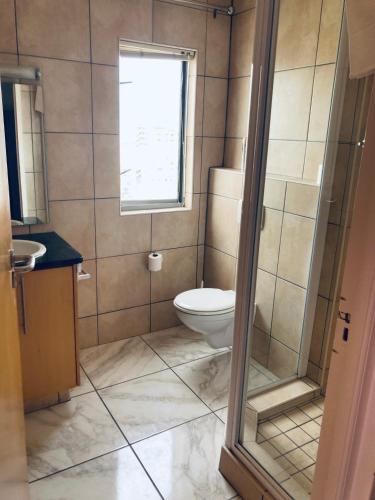 a bathroom with a toilet and a window at Hibernian 10.02 in Cape Town