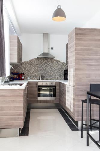 a kitchen with wooden cabinets and a stove top oven at The Queen Luxury Apartments - Villa Marilyn in Luxembourg