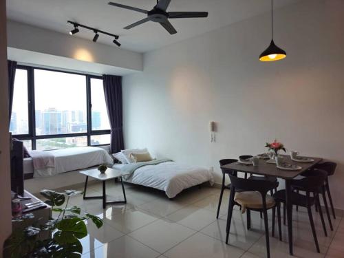 ein Wohnzimmer mit einem Bett und einem Tisch mit Stühlen in der Unterkunft NEW Elegant & Cozy Greenfield Home near Sunway 2-6pax in Petaling Jaya