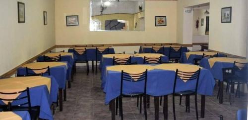 a room filled with tables and chairs with blue tables at Hotel Bellavista in Villa Carlos Paz