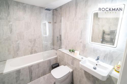 a bathroom with a sink and a toilet and a tub at Royal Oak 1 - FREE PARKING - 2 Bedroom Apartment - 2 bathrooms - Sleeps 6 - Perfect for Contractors - Fast Wi-fi in Brentwood