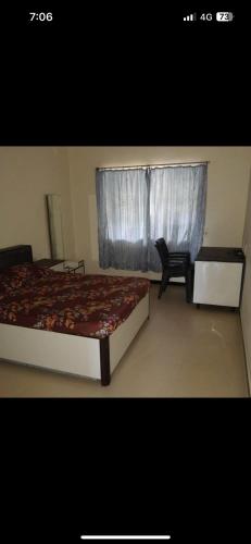 1 dormitorio con 1 cama y ventana con silla en Good earth society, en Bombay
