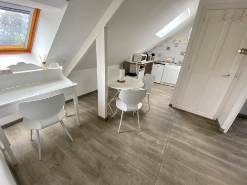 een keuken met een tafel en stoelen in een kamer bij LE PAVILLON RENNAIS in Rennes