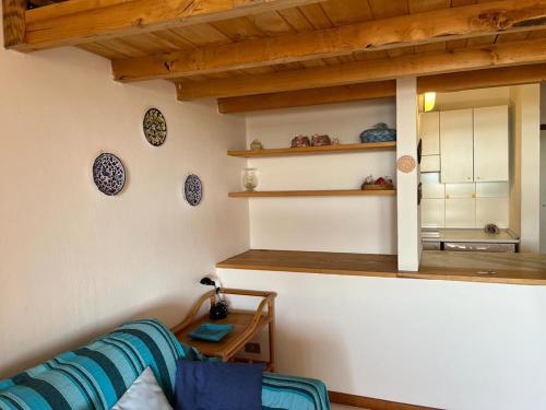 a living room with a blue couch and a mirror at Residence Porto Coda Cavallo in San Teodoro