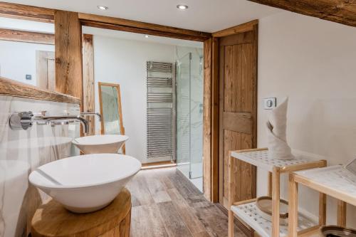 La salle de bains est pourvue d'un lavabo blanc et d'une douche. dans l'établissement Chalet Kieppi - View off Mont-Blanc range, aux Houches