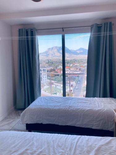 a bedroom with a bed and a large window at Hibernian 10.02 in Cape Town