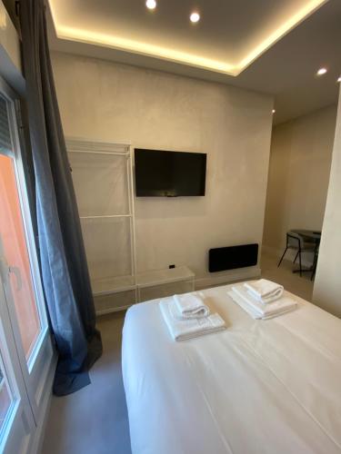 a bedroom with a white bed and a television at Apartamentos "El collado Suites" Soria Centro in Soria