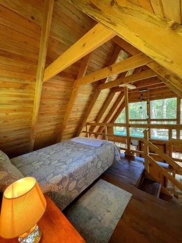 a room with a bed in a wooden attic at Chalet & Kiosko dónde Piedra in San Isidro