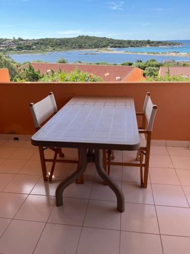a table and two chairs on a balcony with a view at Residence Porto Coda Cavallo in San Teodoro