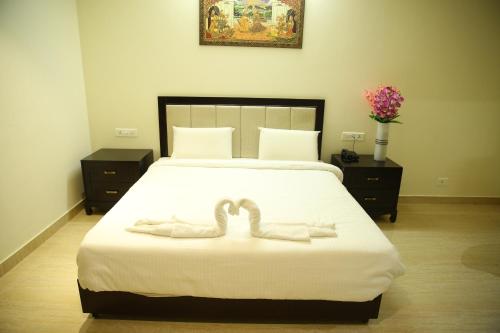 a bedroom with a bed with two heart shaped towels at SREE VEDA INN in Guntūr