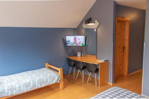 a bedroom with a desk and a bed and a table at Pension Kärnten in Seeboden