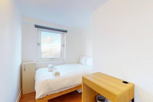 a small bedroom with a bed and a window at Modern 2BD flat in Bethnal Green- 10 min to tube in London