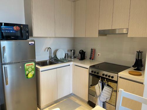 a kitchen with a stainless steel refrigerator and a sink at A Place to Stay 1BR Waters Edge Theme Parks, Yas Island in Abu Dhabi