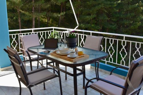a table with chairs and a laptop on a balcony at Igoumenitsa Retiré Apartment in Igoumenitsa