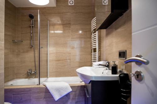 a bathroom with a tub and a sink and a shower at The Queen Luxury Apartments - Villa Marilyn in Luxembourg