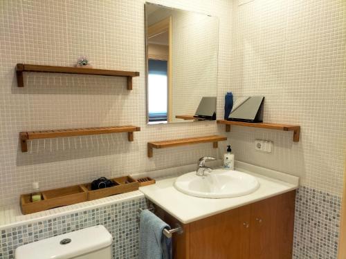Un baño con lavabo, espejo e inodoro. en La Quiniela, en Aviá