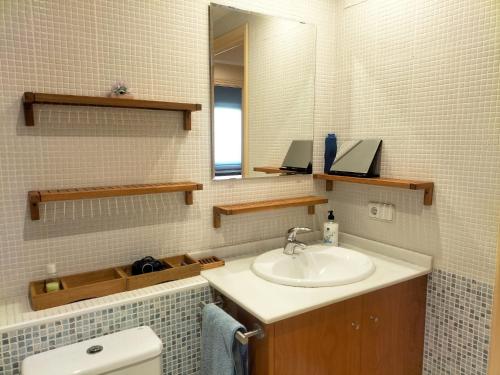 a bathroom with a sink and a mirror and a toilet at La Quiniela in Aviá