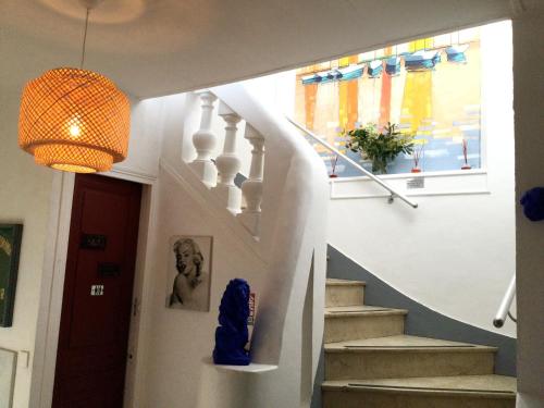 a hallway with stairs and a pendant light at Hotel le Castellamar in Sainte-Maxime